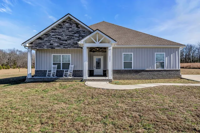 a view of a house with yard and porch