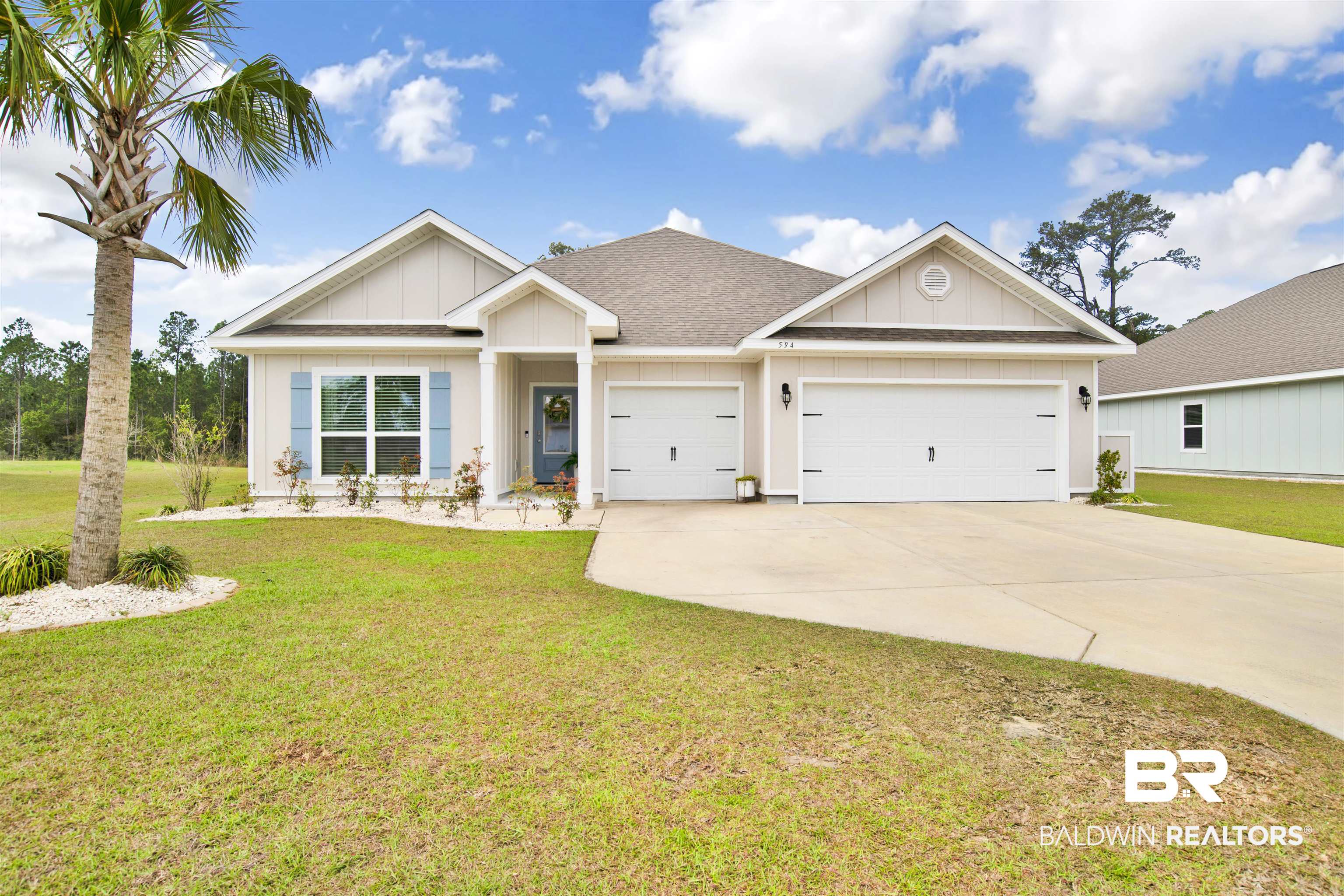 594 Shepard Street Gulf Shores, AL 36542 - Photo 1 of 51 View of front of house with board and batten siding, a front lawn, concrete driveway, a garage, and a shingled roof