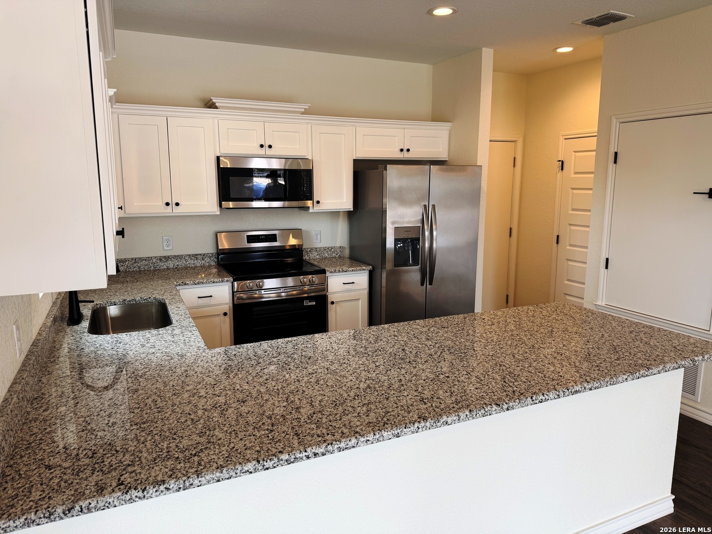 600 A 10th Bandera, TX 78003 - Photo 3 of 13 a kitchen with stainless steel appliances granite countertop a sink a stove and a refrigerator