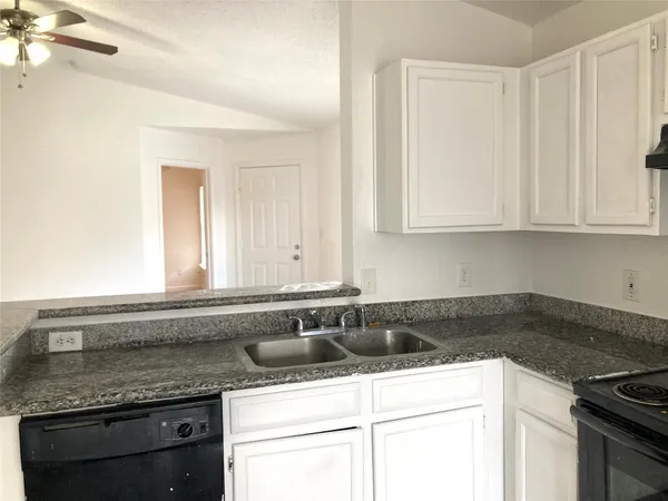 a kitchen with stainless steel appliances granite countertop a sink a stove and dishwasher