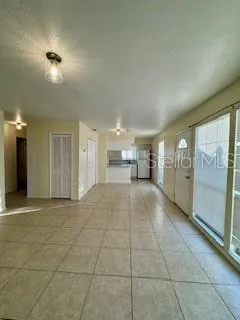 a view of empty room with a kitchen