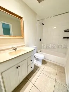 a spacious bathroom with a granite countertop sink a toilet mirror and bathtub