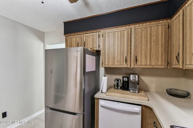 a kitchen with stainless steel appliances granite countertop a refrigerator a sink a stove and white cabinets