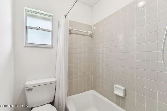 a bathroom with a granite countertop sink a toilet and a mirror