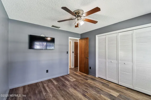a view of a room with a window and a ceiling fan