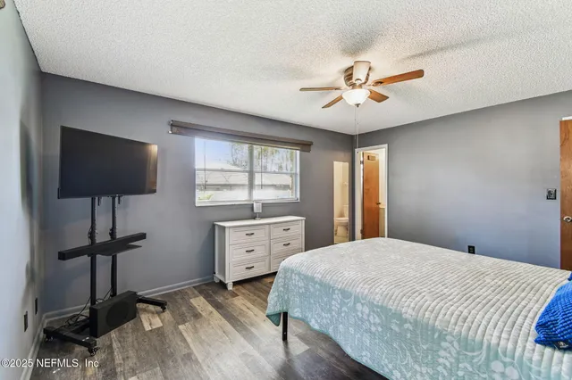 a bedroom with a bed and a tv on the dresser
