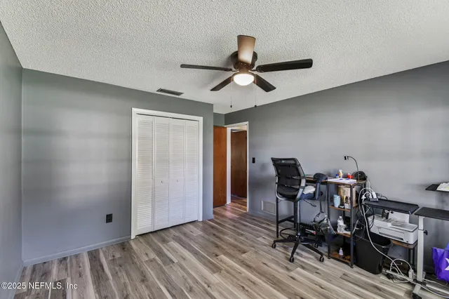 a view of an empty room with wooden floor and a balcony