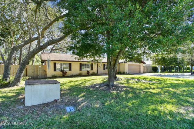 a front view of a house with yard and green space