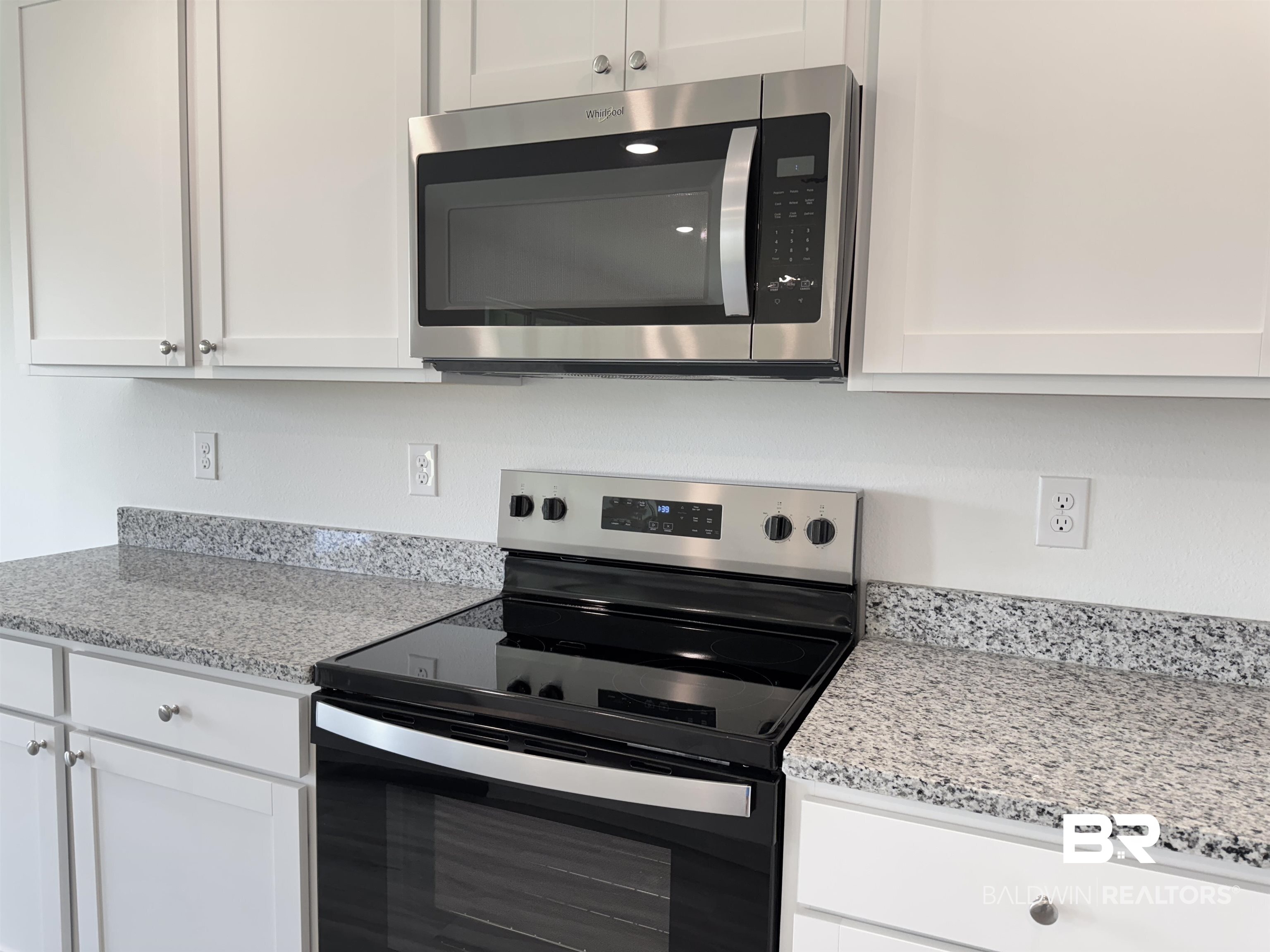 22072 Aleutian Avenue Foley, AL 36535 - Photo 35 of 47 Kitchen with appliances with stainless steel finishes, white cabinets, and light stone countertops
