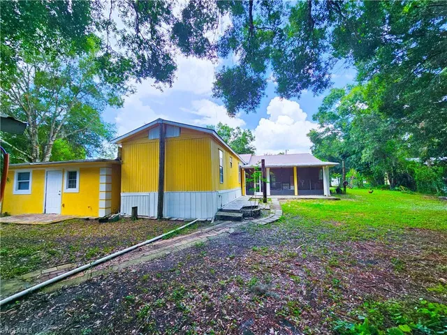 a view of a house with a yard and sitting area