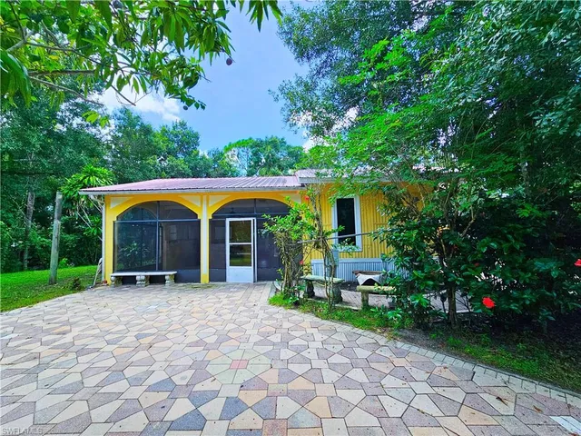 a view of house with garden and tall trees
