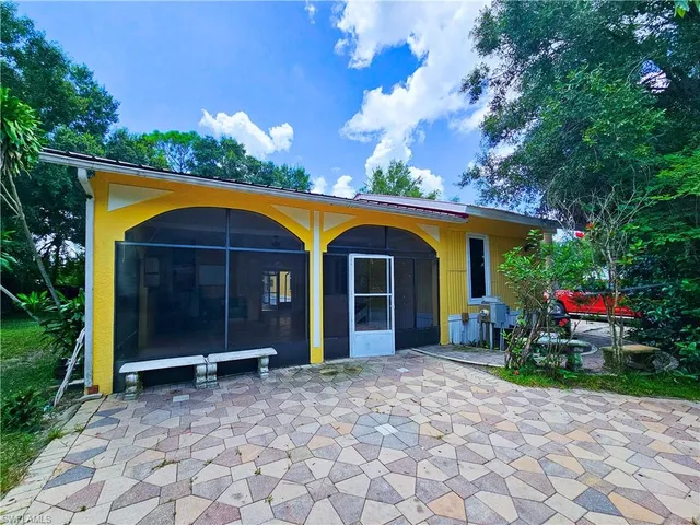 a view of a house with backyard and sitting area