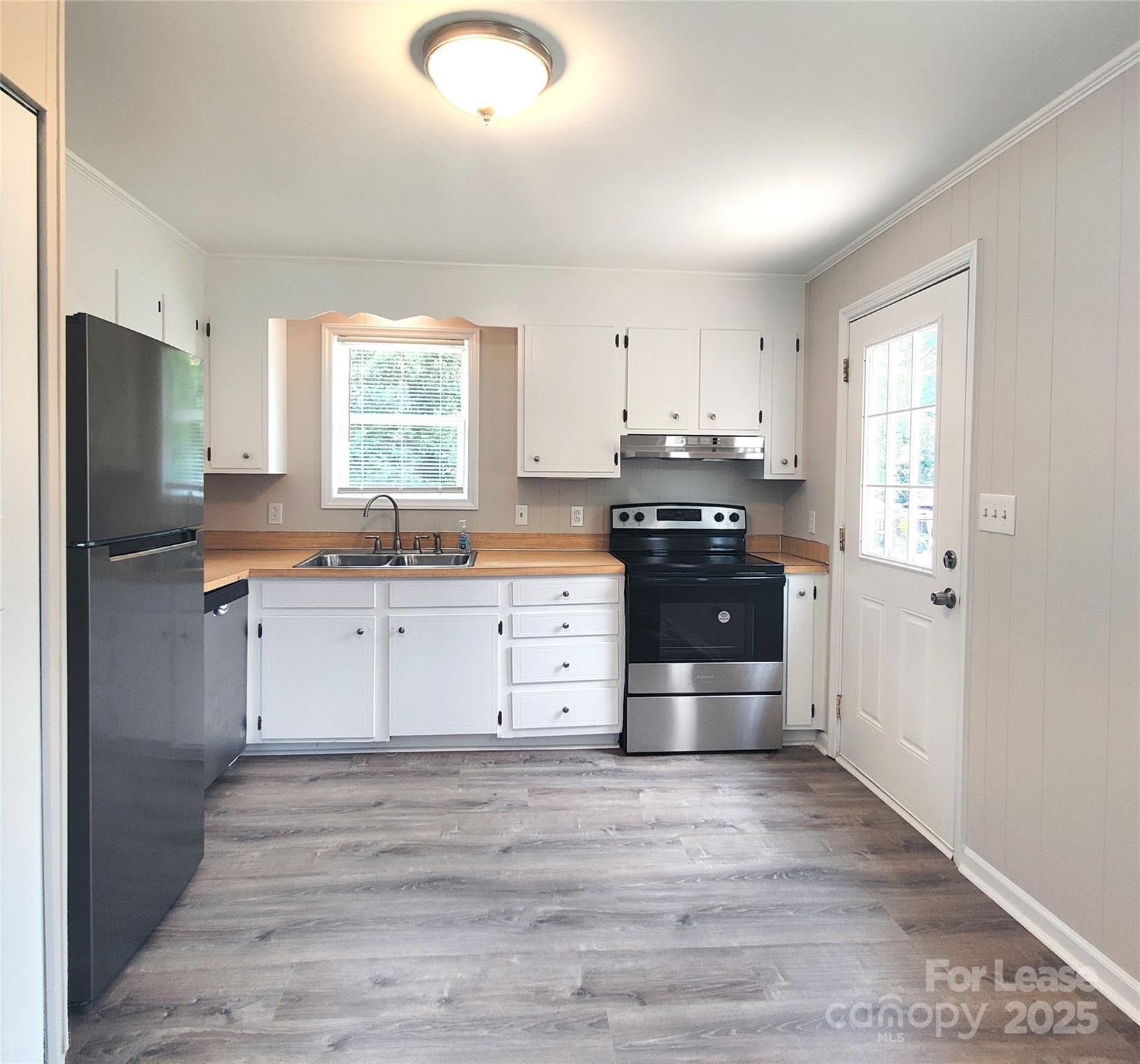 5325 Hemby Road, Unit B Weddington, NC 28104 - Photo 5 of 19 a kitchen with stainless steel appliances granite countertop a stove and a refrigerator