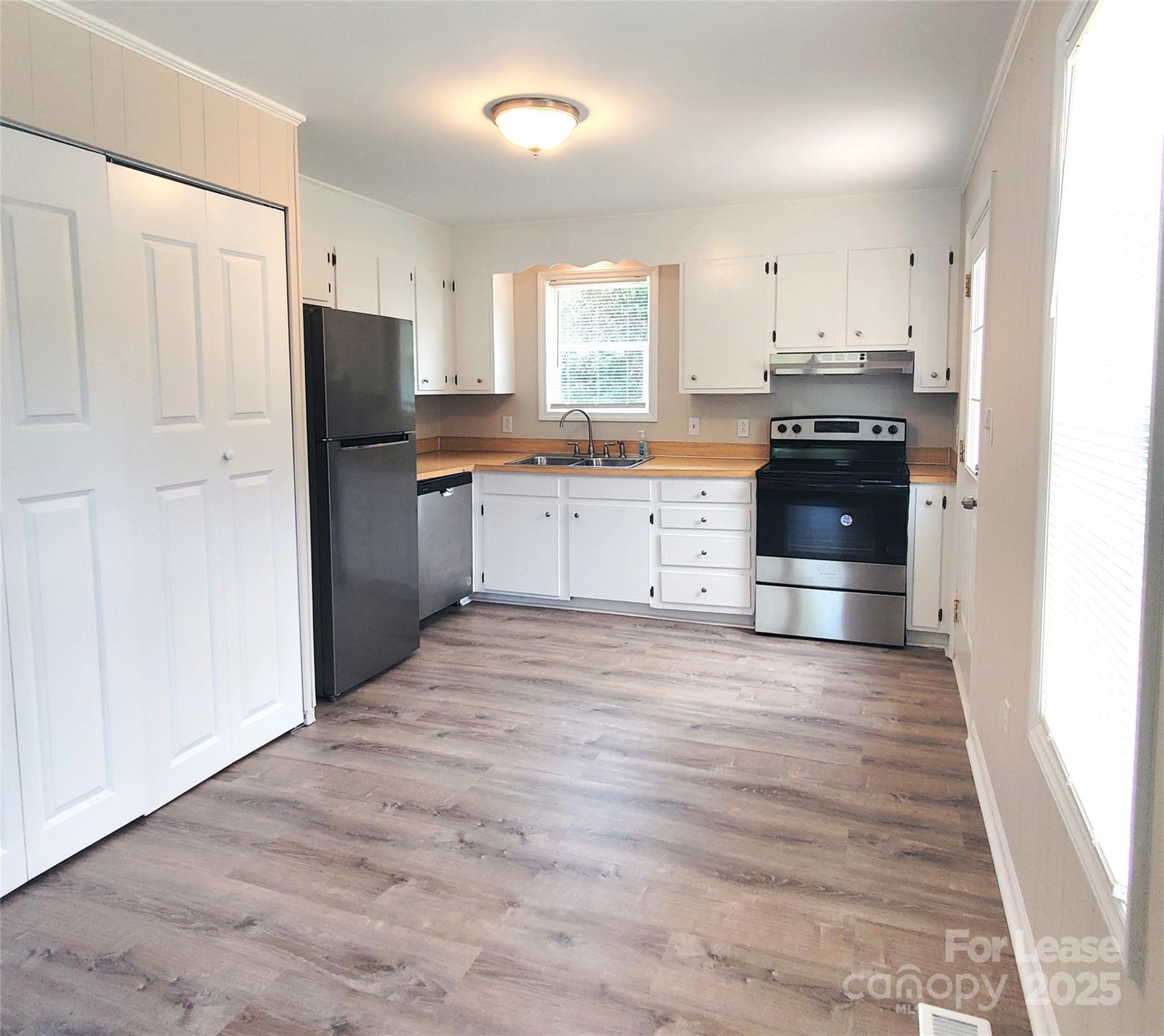 5325 Hemby Road, Unit B Weddington, NC 28104 - Photo 6 of 19 a kitchen with granite countertop a refrigerator stove top oven and sink