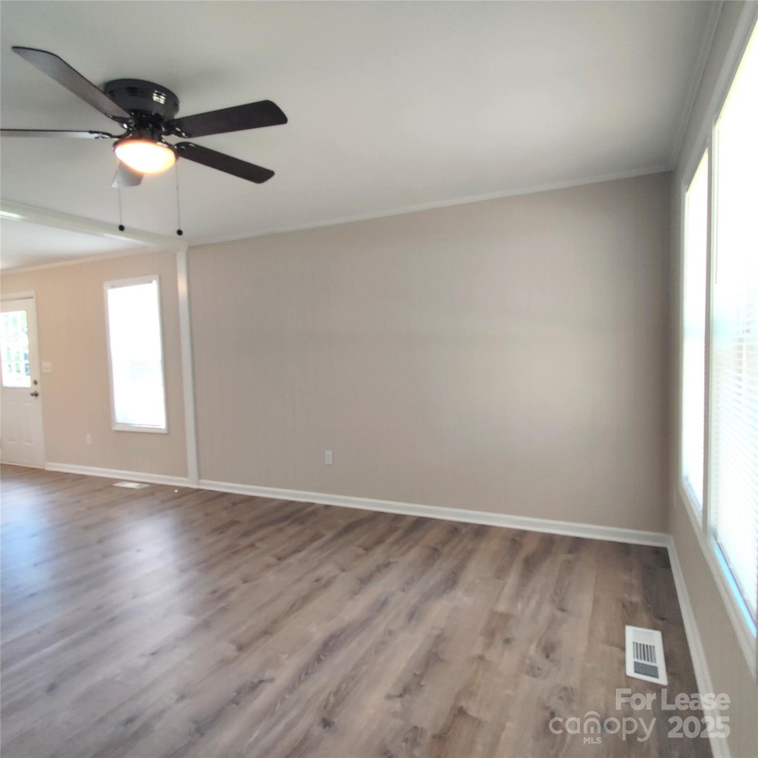 5325 Hemby Road, Unit B Weddington, NC 28104 - Photo 8 of 19 an empty room with wooden floor fan and windows