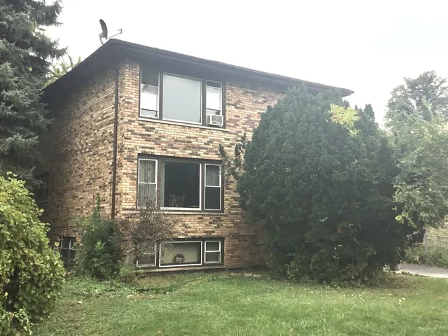 a backyard of a house with table and chairs