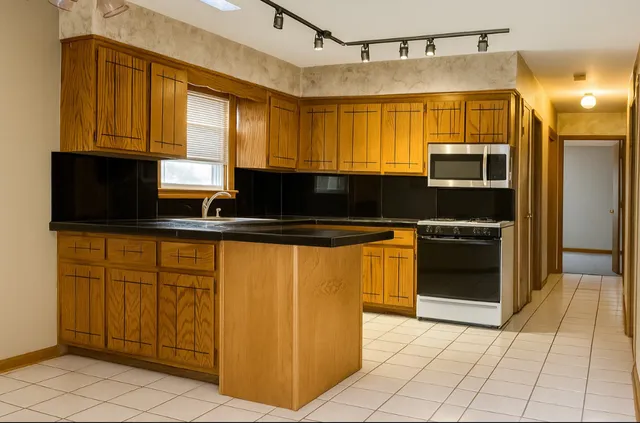 a kitchen with stainless steel appliances granite countertop a stove a sink and a microwave
