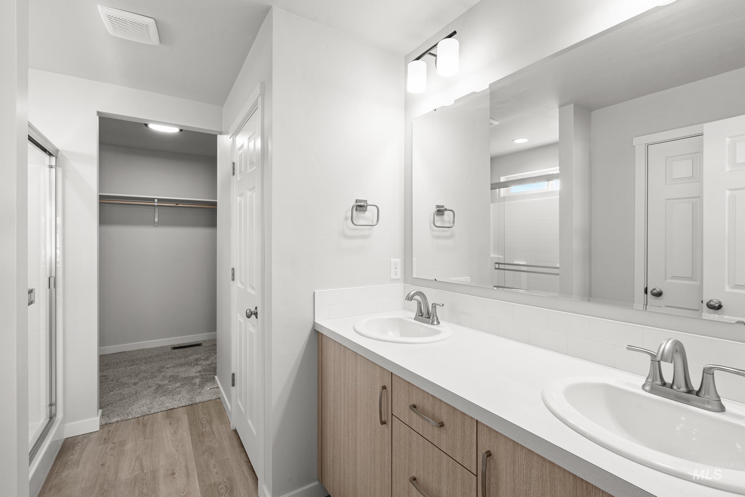 1687 Dyer Street Middleton, ID 83644 - Photo 27 of 28 Bathroom with double vanity, a shower stall, light wood-style flooring, and a spacious closet