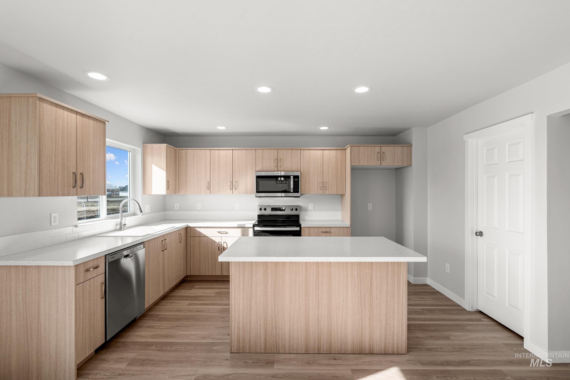 1687 Dyer Street Middleton, ID 83644 - Photo 3 of 28 Kitchen with light wood finish cabinetry, stainless steel appliances, light wood-style flooring, recessed lighting, and a center island