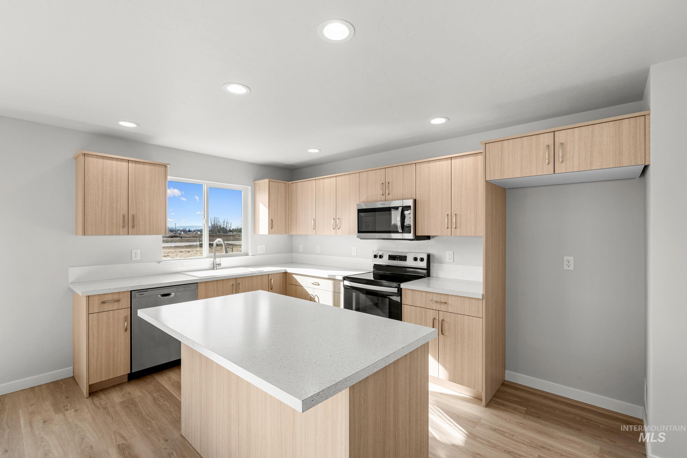 1687 Dyer Street Middleton, ID 83644 - Photo 4 of 28 Kitchen with light wood finish cabinets, a center island, stainless steel appliances, light countertops, and light wood finished floors
