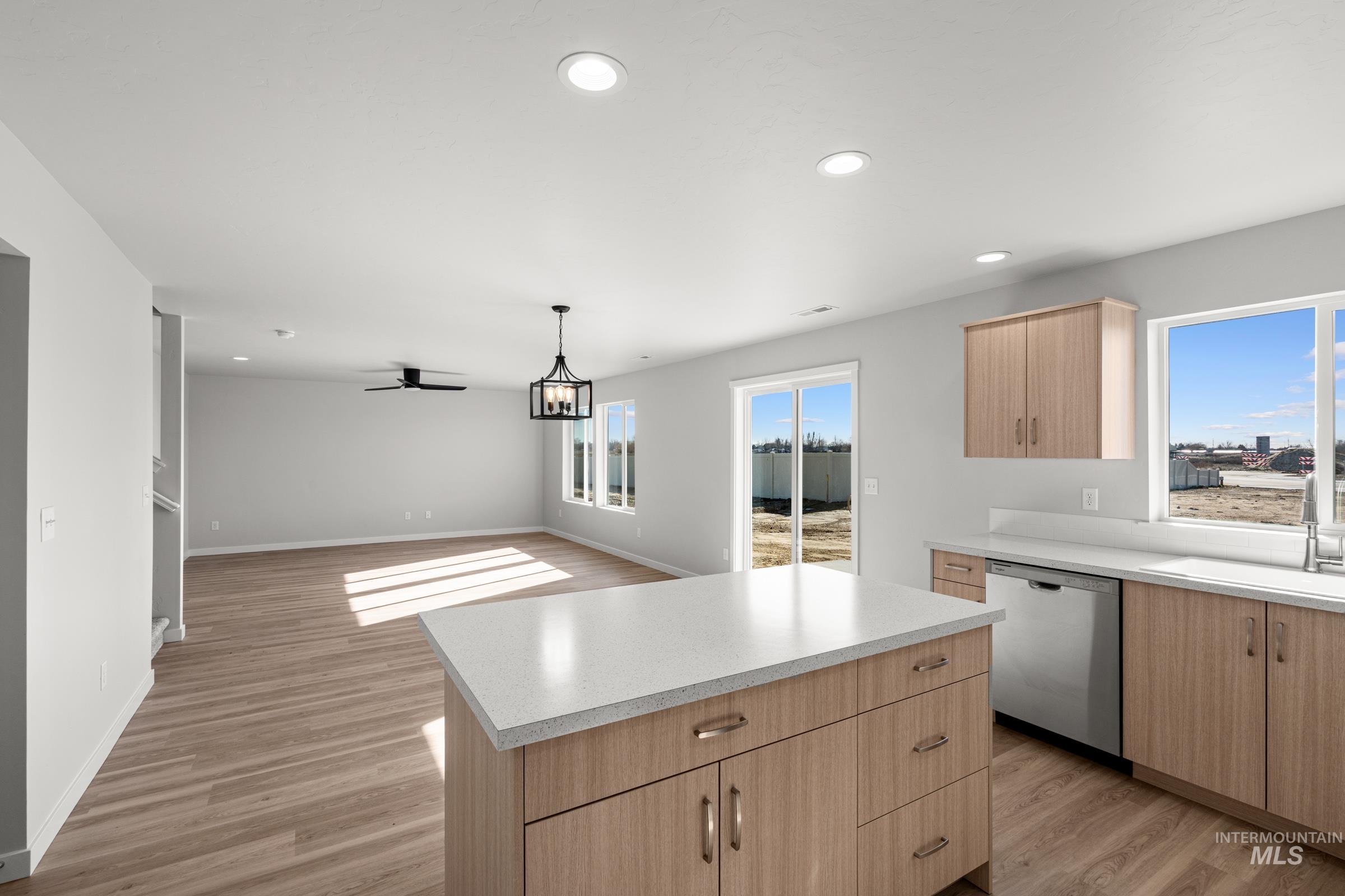 1687 Dyer Street Middleton, ID 83644 - Photo 6 of 28 Kitchen with light wood finish cabinetry, light wood-style floors, stainless steel dishwasher, and a kitchen island