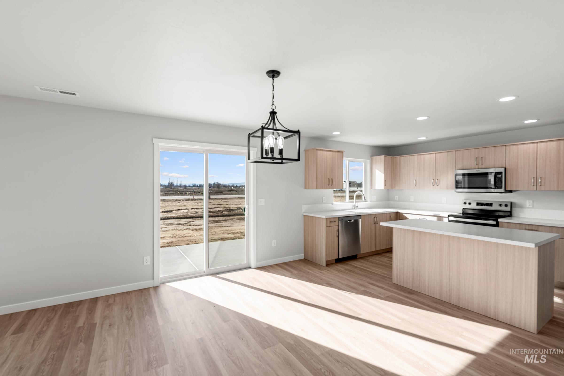 1687 Dyer Street Middleton, ID 83644 - Photo 8 of 28 Kitchen with light countertops, light wood finish cabinetry, light wood-type flooring, and stainless steel appliances
