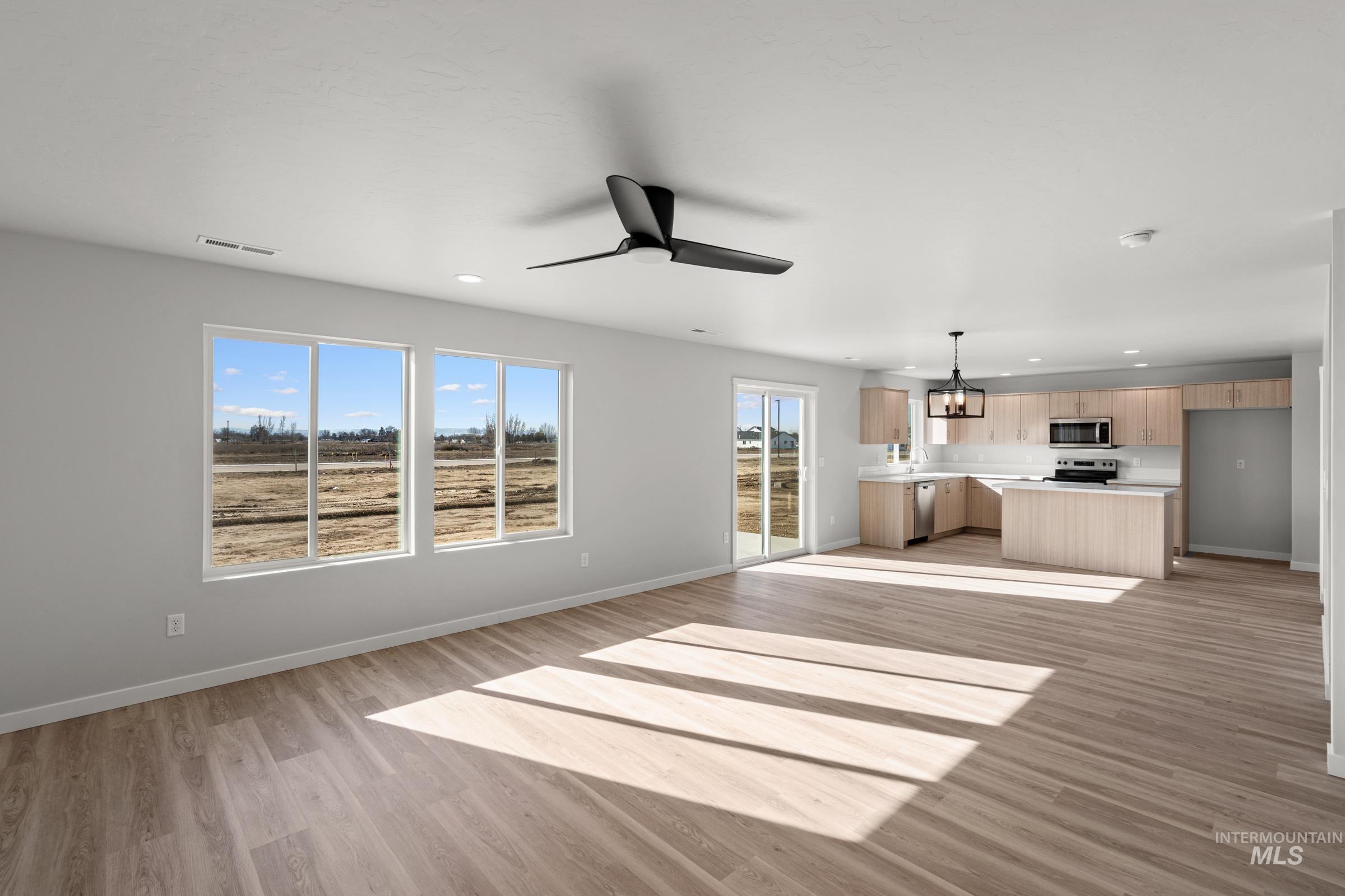 1687 Dyer Street Middleton, ID 83644 - Photo 10 of 28 Unfurnished living room featuring light wood-type flooring, ceiling fan, and suspended lighting