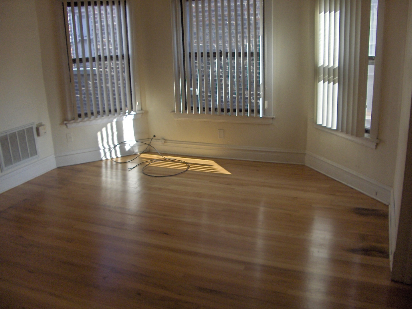 4039 North Long Avenue, Unit 1 Chicago, IL 60641 - Photo 6 of 20 an empty room with wooden floor and windows