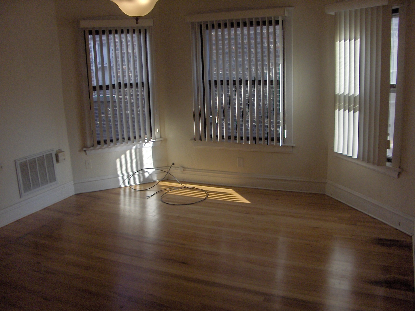 4039 North Long Avenue, Unit 1 Chicago, IL 60641 - Photo 7 of 20 an empty room with wooden floor and windows