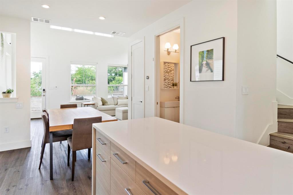 911 Stobaugh Street, Unit 2 Austin, TX 78757 - Photo 7 of 26 Open-concept design featuring wood-finish flooring, a white kitchen island with integrated storage, and recessed lighting