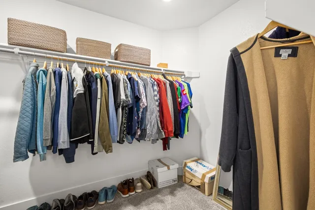 a view of walk in closet with clothes and shoes