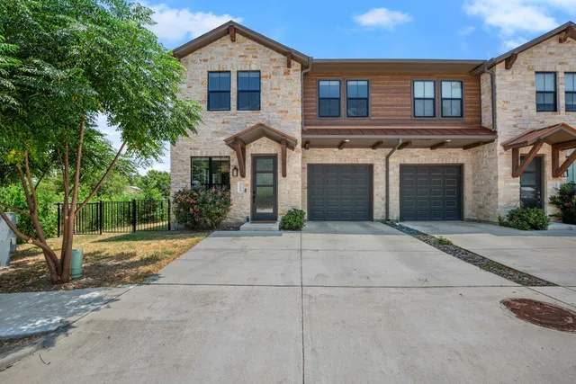 a view of a house with a yard and potted plants