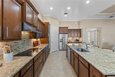 a kitchen with stainless steel appliances granite countertop a sink a stove and a refrigerator