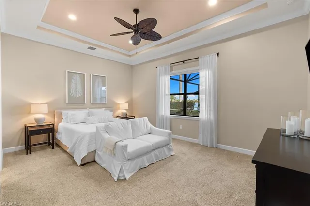 a spacious bedroom with a large bed and a chandelier