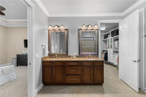 a bathroom with a granite countertop sink double vanity and a mirror