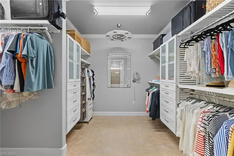 a view of walk in closet with clothes and shoes