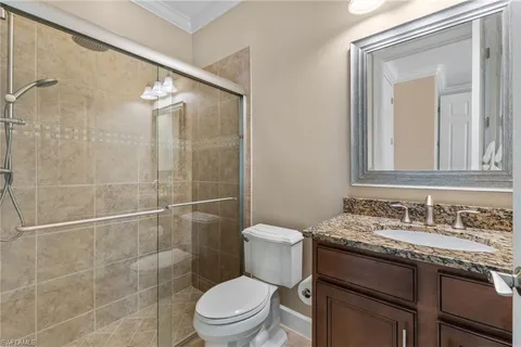 a bathroom with a granite countertop sink toilet and shower