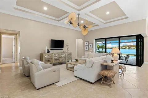 a living room with furniture a flat screen tv and a large window