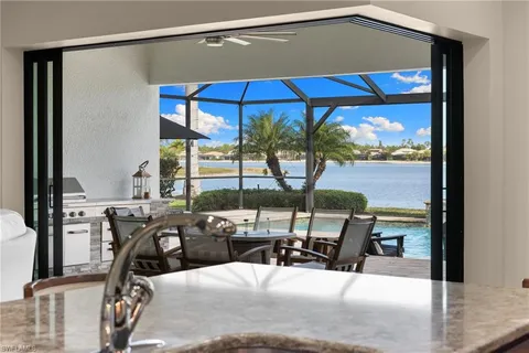 a view of a balcony with chairs and table under an umbrella