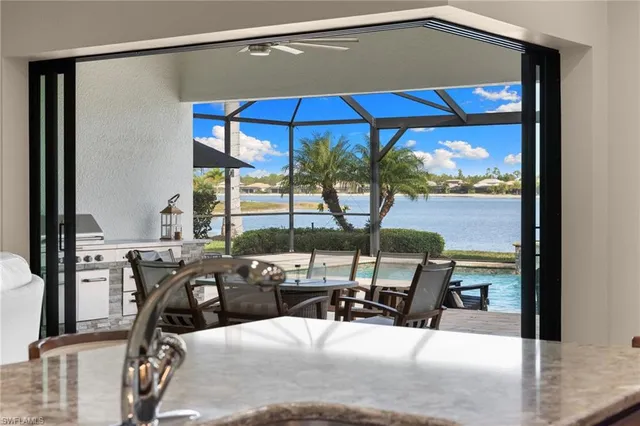 a view of a balcony with chairs and table under an umbrella