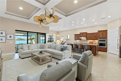 a living room with furniture kitchen view and a large window