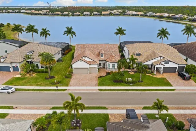 an aerial view of a house with a yard and lake view