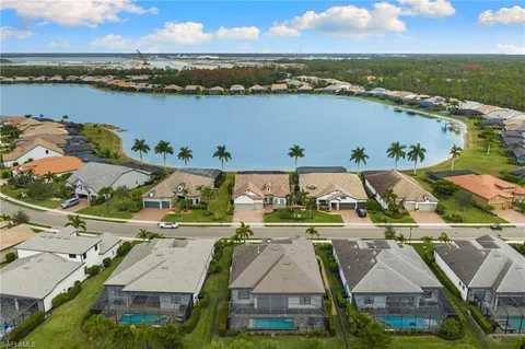 an aerial view of residential houses with outdoor space and ocean view