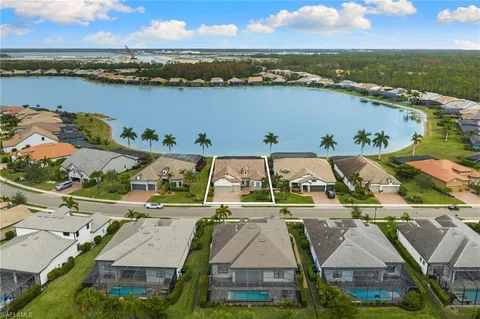 an aerial view of residential houses with outdoor space and ocean view