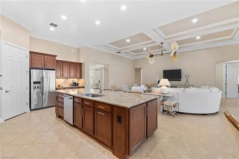 a large kitchen with stainless steel appliances a sink and cabinets