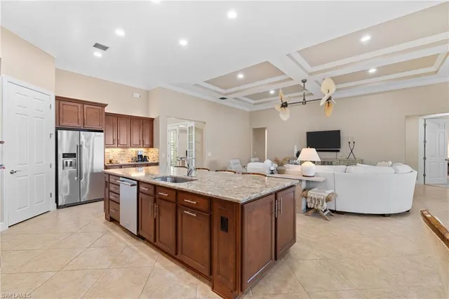 a large kitchen with stainless steel appliances a sink and cabinets
