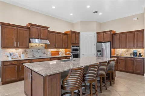 a kitchen with granite countertop a table chairs sink and cabinets