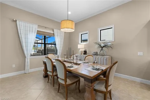 a view of a dining room and livingroom with furniture wooden floor a rug a fireplace and a chandelier