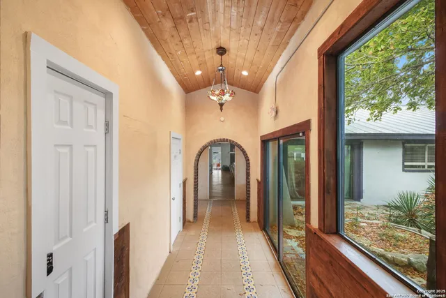an aerial view of residential house with outdoor space and trees all around