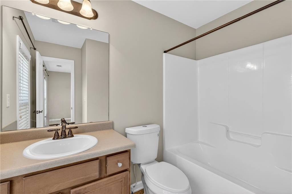 1186 Lake Point Way Suwanee, GA 30024 - Photo 29 of 35 a bathroom with a sink a toilet and shower